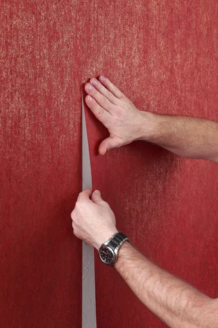 Illustration - Ihr Experte für schönes Wohnen - Ein Handwerker klebt eine Tapete an die Wand, er setzt eine zweite Bahn direkt an die erste, so dass die Naht nicht mehr zu sehen ist.